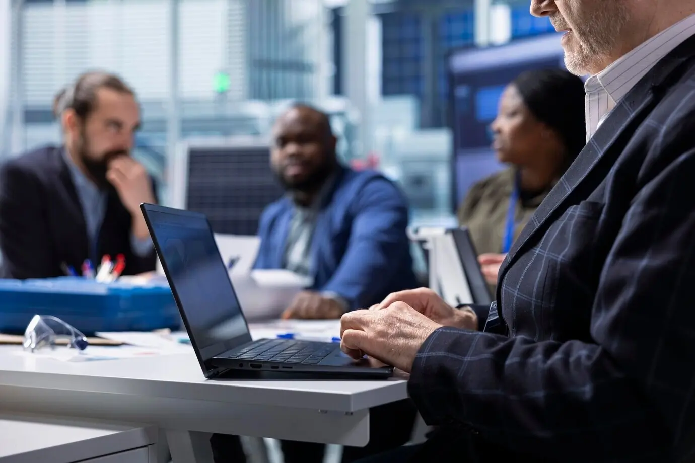Equipo de ingeniería de una fábrica de fotovoltaicos que utiliza un portátil para investigar.