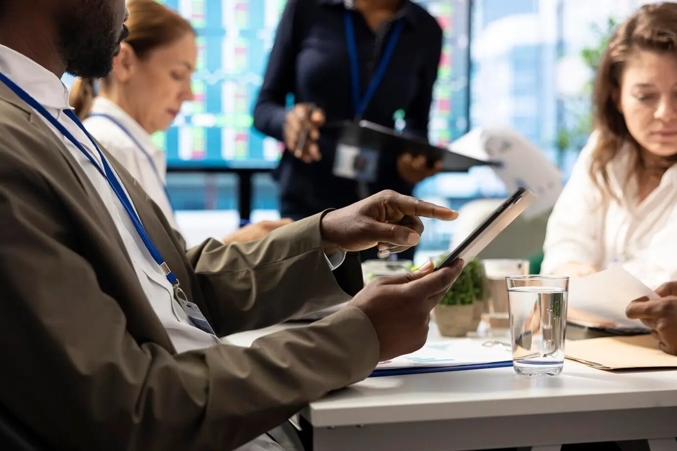 Accionista examinando infografías y asignación de recursos en una tableta